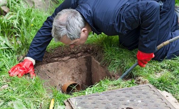 septic tank pumping jacksonville septic inspector checking out system to make sure it is n good working condition looking in hole
