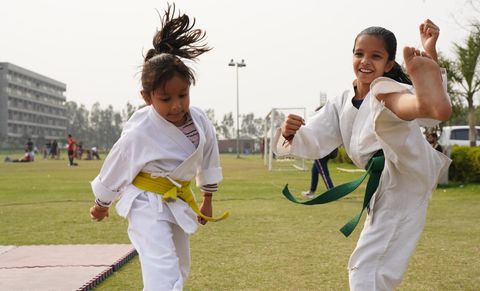 kids with yellow and green belt doing karate